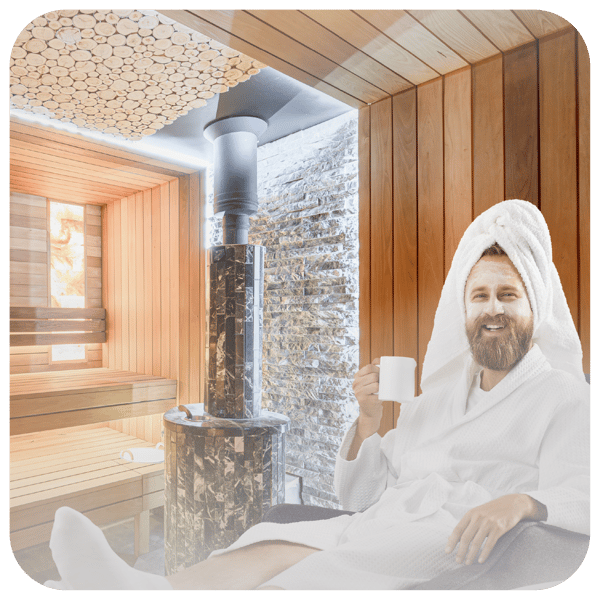 Man in spa attire robe and towel in home sauna sipping from coffee mug